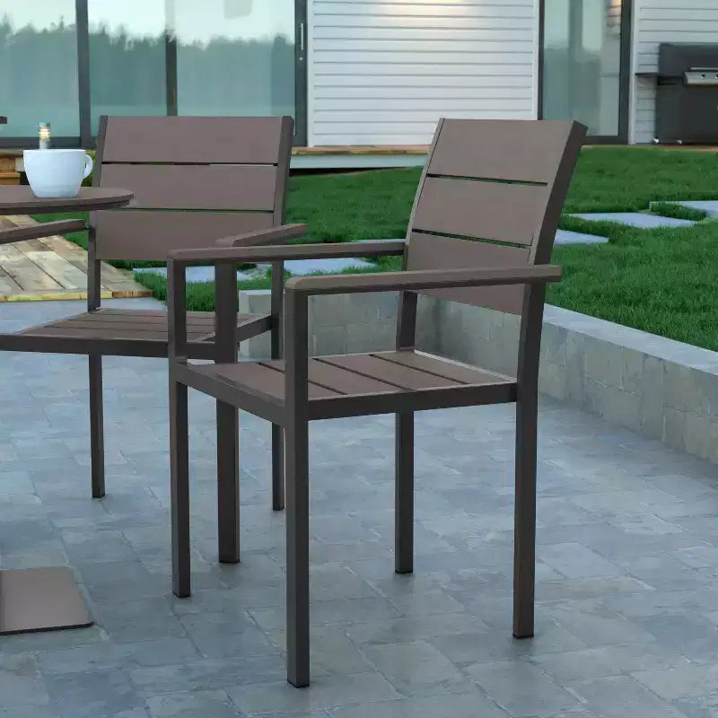 Chaise d'extérieur empilable Emma and Oliver avec assise, dossier et accoudoirs à lattes en polyéthylène imitation teck et cadre métallique