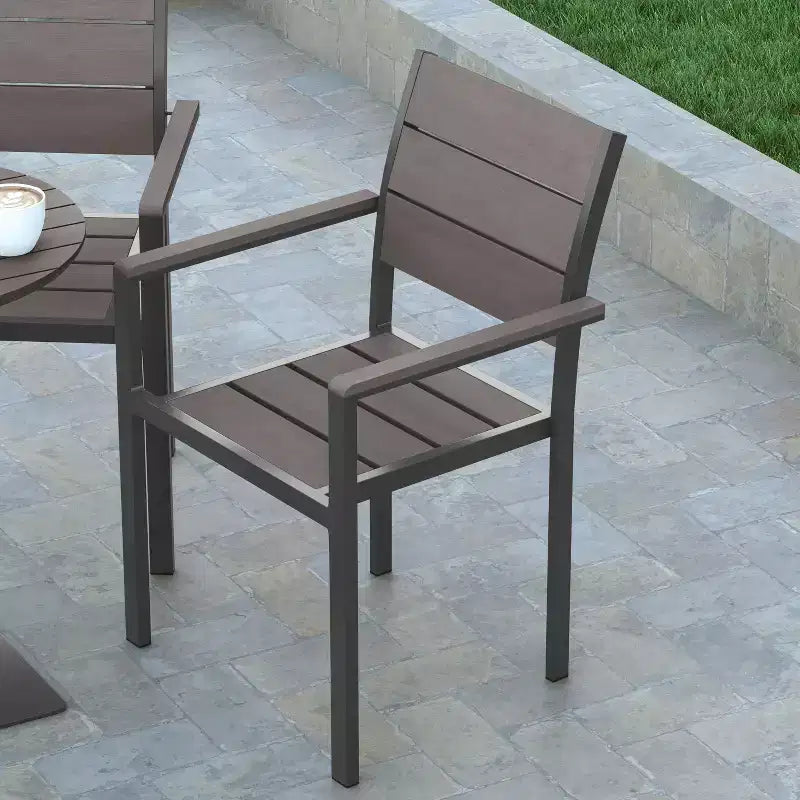 Chaise d'extérieur empilable Emma and Oliver avec assise, dossier et accoudoirs à lattes en polyéthylène imitation teck et cadre métallique
