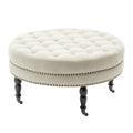 Pouf de cocktail rond en tissu Indy Porthos Home avec pieds et roulettes en bois d'hévéa