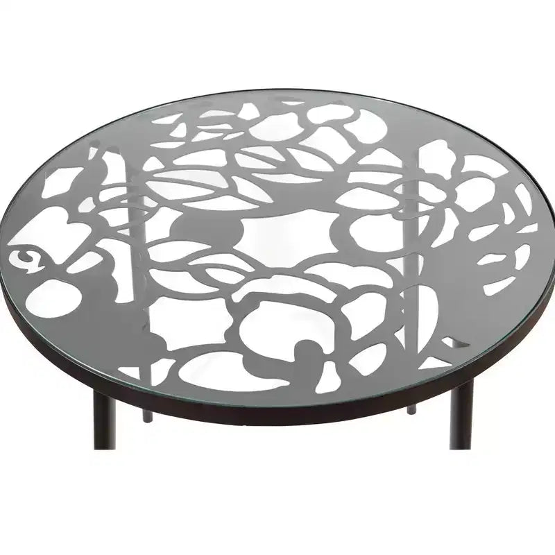 LeisureMod Devon Ensemble de salle à manger d'extérieur 5 pièces - Table ronde en verre avec 4 chaises empilables noires à motif floral
